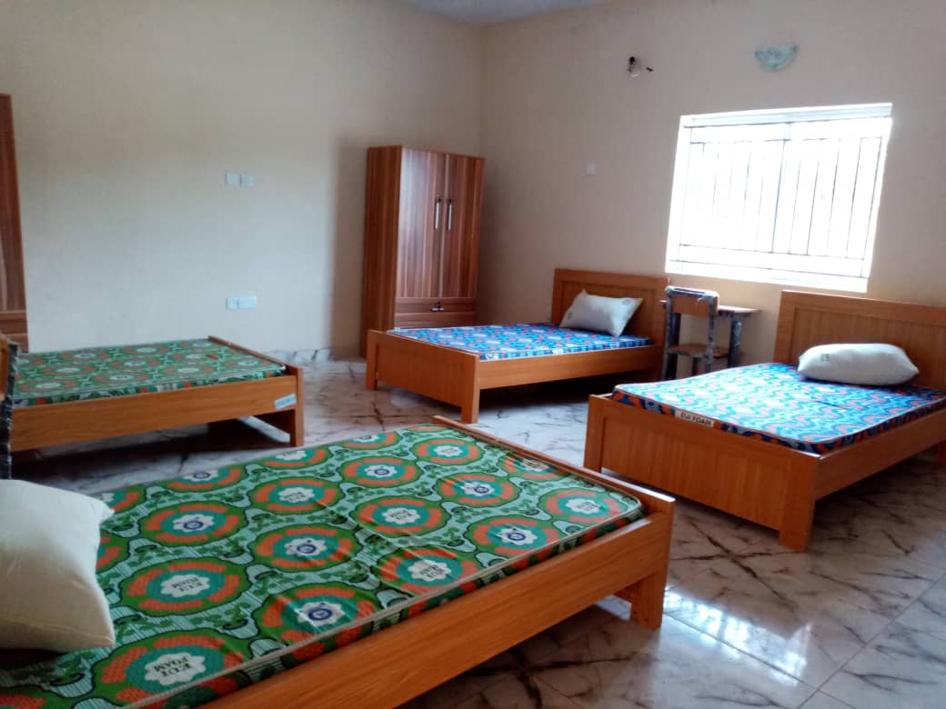 Furnished hostel room with multiple beds